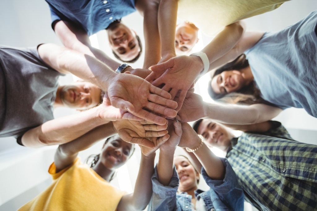 Close-up of volunteers with hand stacked. Image shot from below hand stack.